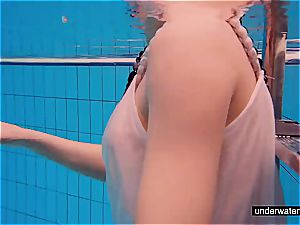 redhead honey swimming nude in the pool